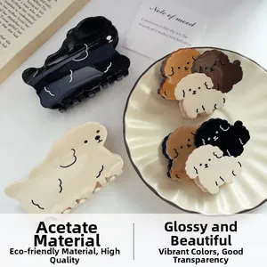 Detailweergave van de crème acetaat puppy haarklemmen met hoogglans op een bureau