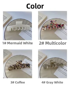 Detail view of large acetate hair claws in pearly white floral and marble patterns