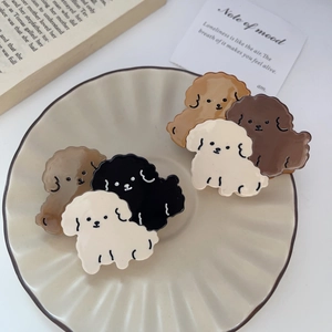 Puppy haarclips van acetaat in crème bruin en zwart kleuren op een keramieken bord