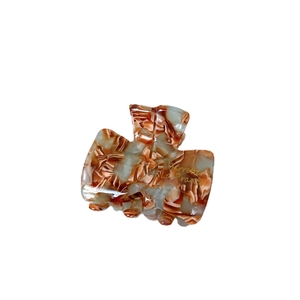 Elegant marble acetate hair claw clip with amber texture and gold lettering
