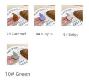 Détail de pinces à cheveux ailes d'ange en acétate en caramel, violet, beige et vert