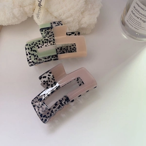 Retro acetate hair claw clips in mint green and smoky pink with a marbled texture design