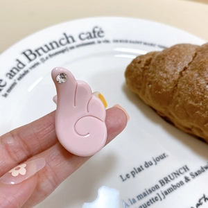 Gros plan d'une pince à cheveux aile d'ange rose avec strass dans un décor de café chic