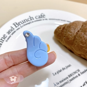Vue détaillée de la pince à cheveux bleue en forme d'aile avec strass sur assiette