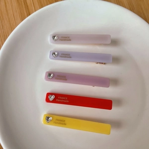 Détail de barrettes rectangulaires colorées en acétate avec décorations cœur cristal