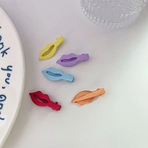 Lot de 5 pinces à cheveux en forme de lèvres aux tons bonbon mats sur une surface blanche