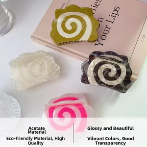 Close-up of spiral acetate shark hair clips in green, white, tortoiseshell, and neon pink
