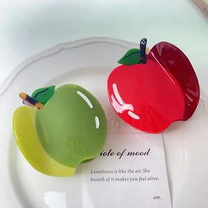 Détail de pinces à cheveux en forme de pomme avec dégradé rouge et vert en résine