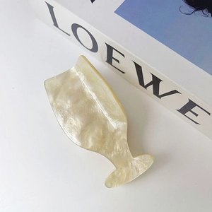 Detail of elegant cream acetate hair claw clip with a glossy mother of pearl finish