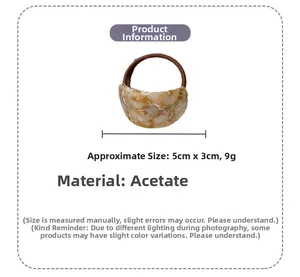 Detail view of acetate hair tie with dimensions 5cm by 3cm and beige marble texture