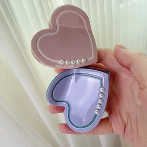 Vista dettagliata di mollette per capelli a cuore con perle bianche nei colori rosa e viola