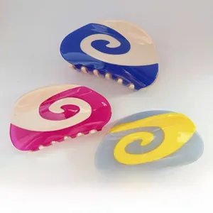 Dettaglio macro di fermagli per capelli in acetato con elegante motivo a spirale