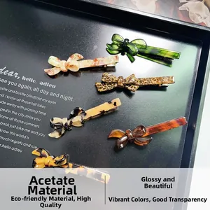 Detail view of 6-piece acetate bow hair clips in assorted marble and tortoise patterns