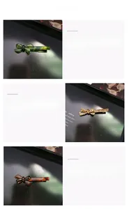 Detailed macro view showing green, leopard, and amber acetate bow hair clips on a black tray