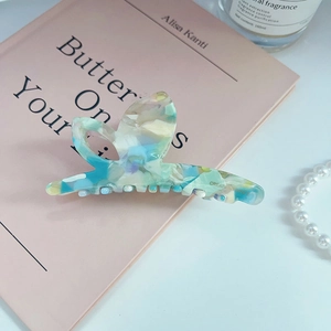 Macro detail of high-end acetate hair claw clip with marble texture and side lettering
