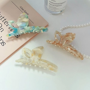 Three elegant acetate butterfly hair claws in marble textures with pearl decor