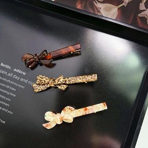 Three-piece acetate bow hair clips set featuring amber, leopard, and marble patterns