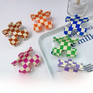 Lot de six pinces à cheveux en acétate à damier en forme de puzzle sur plateau blanc