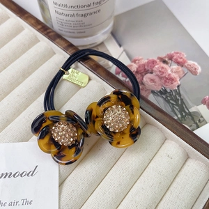 Detail of camellia hair scrunchie with tortoiseshell finish and sparkling rhinestones