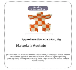Détail de la pince à cheveux puzzle en acétate avec motif à damier orange