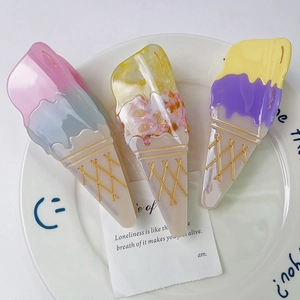 Trois pinces à cheveux en forme de cornet de glace sur une assiette en céramique blanche
