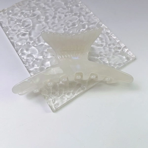 Detail of elegant cream acetate fishtail hair claw clip with pearlescent finish