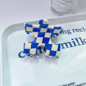 Pince à cheveux motif damier bleu et beige en forme de puzzle avec fini brillant