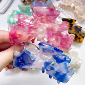 Detailed view of large acetate bow hair claws with premium pearlescent marble texture