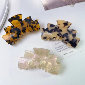 Three acetate bow shark hair clips in tortoiseshell and marble patterns for women