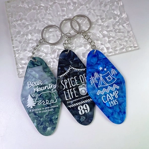Three vintage acrylic diamond-shaped hotel keychains with marble texture and silver rings