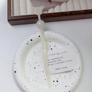 Vue détaillée d'une épingle à cheveux papillon avec perle en acétate sur plat