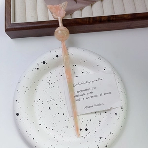Détail d'une épingle à cheveux en acétate avec motif papillon sur plaque céramique
