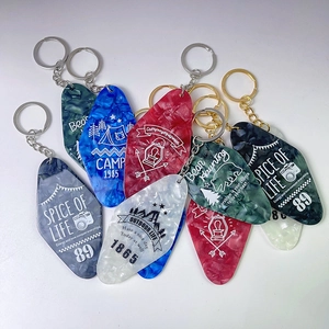 Macro shot of vintage hotel-style acrylic keychains with mountain and camping motifs