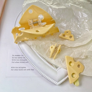 Set di mollette per capelli a forma di formaggio giallo carino su un vassoio bianco