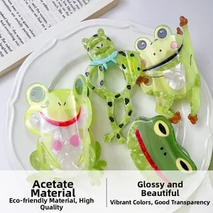 Detailed set of four green acetate frog hair claws displayed on a white ceramic plate