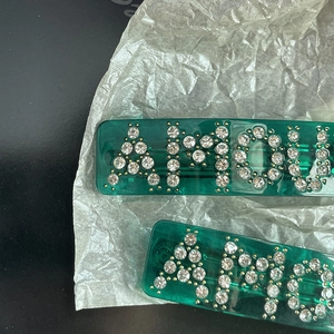 Translucent emerald green hair clips set with AMOUR rhinestone lettering and spring grip