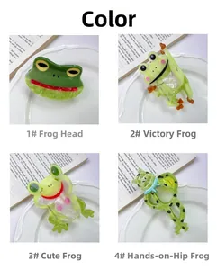 Detail of four green cartoon frog hair claws in acetate with cute facial expressions
