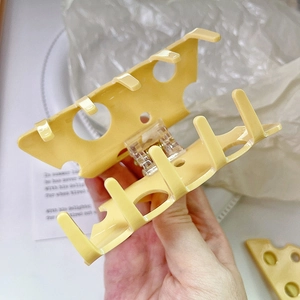 Dettaglio della molletta per capelli gialla a forma di formaggio con design traforato
