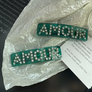 Elegant emerald green resin hair clips set with crystal AMOUR lettering and rhinestones