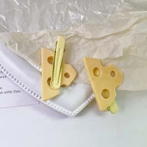 Dettaglio di fermagli per capelli creativi a forma di formaggio con superficie testurizzata