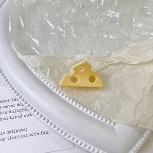 Dettaglio di una graziosa pinza per capelli a forma di formaggio giallo su un vassoio