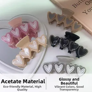 Detailansicht der Acetat-Herzhaarklammern in verschiedenen Pastellfarben auf einem Magazin