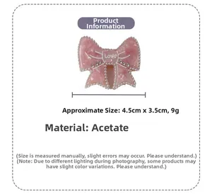 Detailed view of pink acetate bow hair clip with faux pearls and metal LOVE emblem
