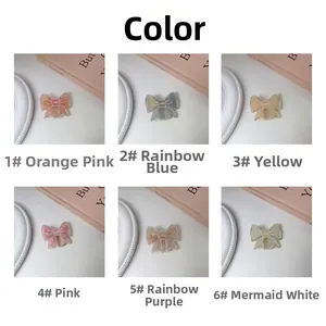 Close-up of bow-shaped hair clips with LOVE engraving in six assorted pastel colors