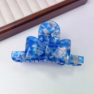 Detailed close-up of blue and white acetate bow hair claw clip with France Handmade text