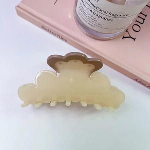 Dettaglio del fermaglio per capelli in acetato a forma di nuvola, crema e marrone