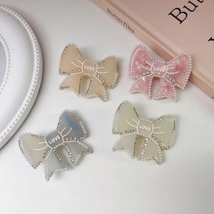 Elegant bow hair clips with pearls, rhinestones, and LOVE text in four pastel colors