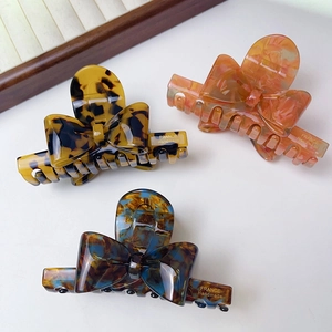 Three-piece set of elegant bow hair claws in marble and tortoiseshell acetate finish
