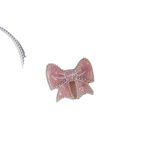 Pink marble bow hair clip with pearl edges and LOVE rhinestone lettering on white