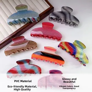 Detail view of large PVC hair claw clips in various patterns like zebra and glitter pink